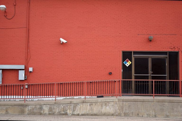 Explaining Why Crime Will Touch Close to a Third of Britain’s Businesses This Year Security camera and rear entrance on a commercial building: Explaining Why Crime Will Touch Close to a Third of Britain's Businesses This Year