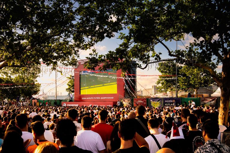 How Football Fans Can Keep Track of a Busy Matchday Football supporters watching a match on a big screen at an outdoor fan zone