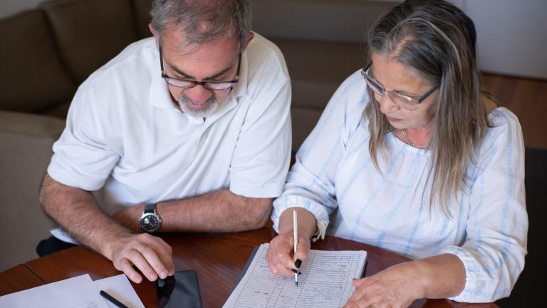 A hasty pension withdrawal today can undermine your retirement and estate plans A hasty pension withdrawal today can undermine your retirement and estate plans: an older couple going through pension and retirement paperwork together at home